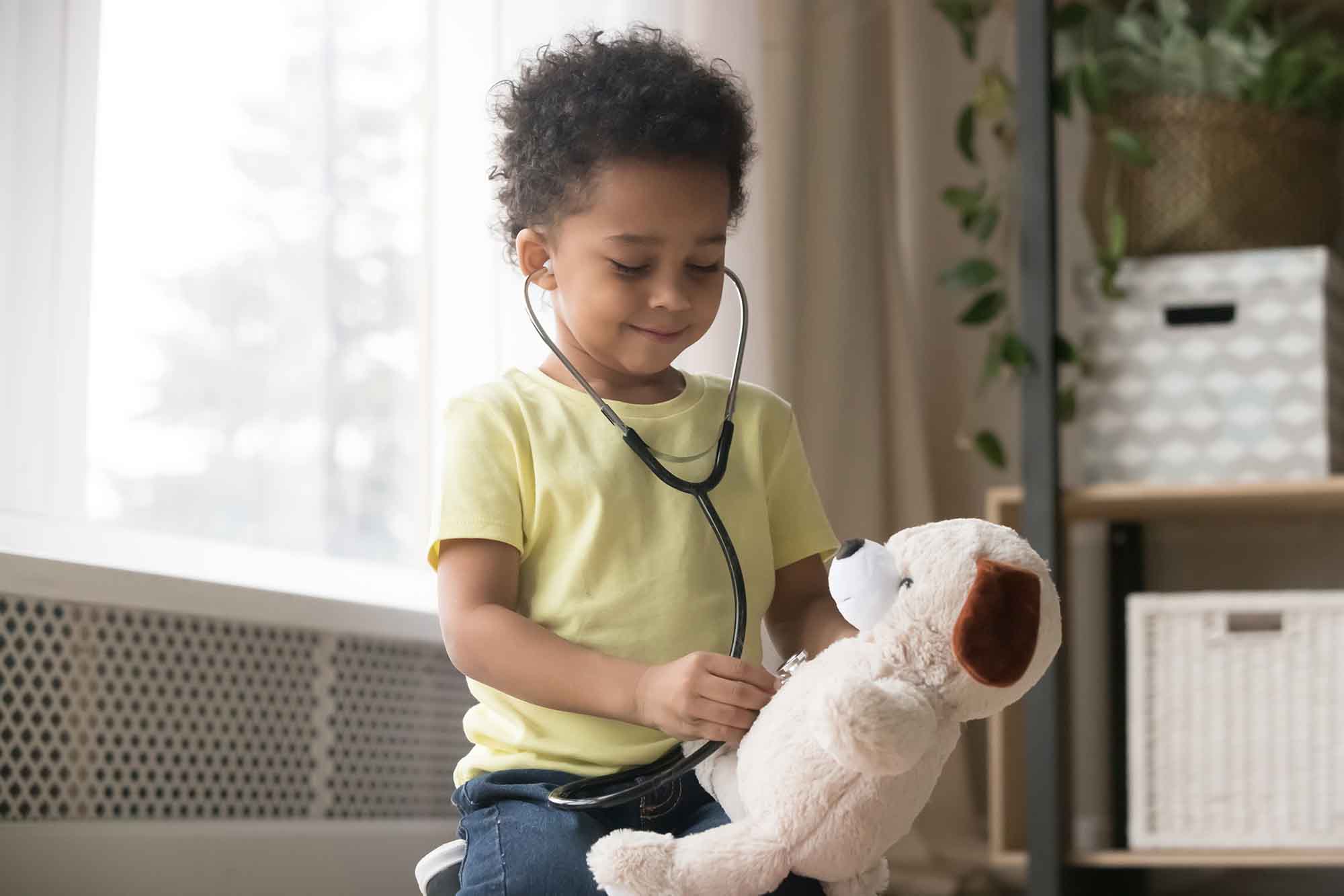 little boy listening to stuffed animal's heart beat