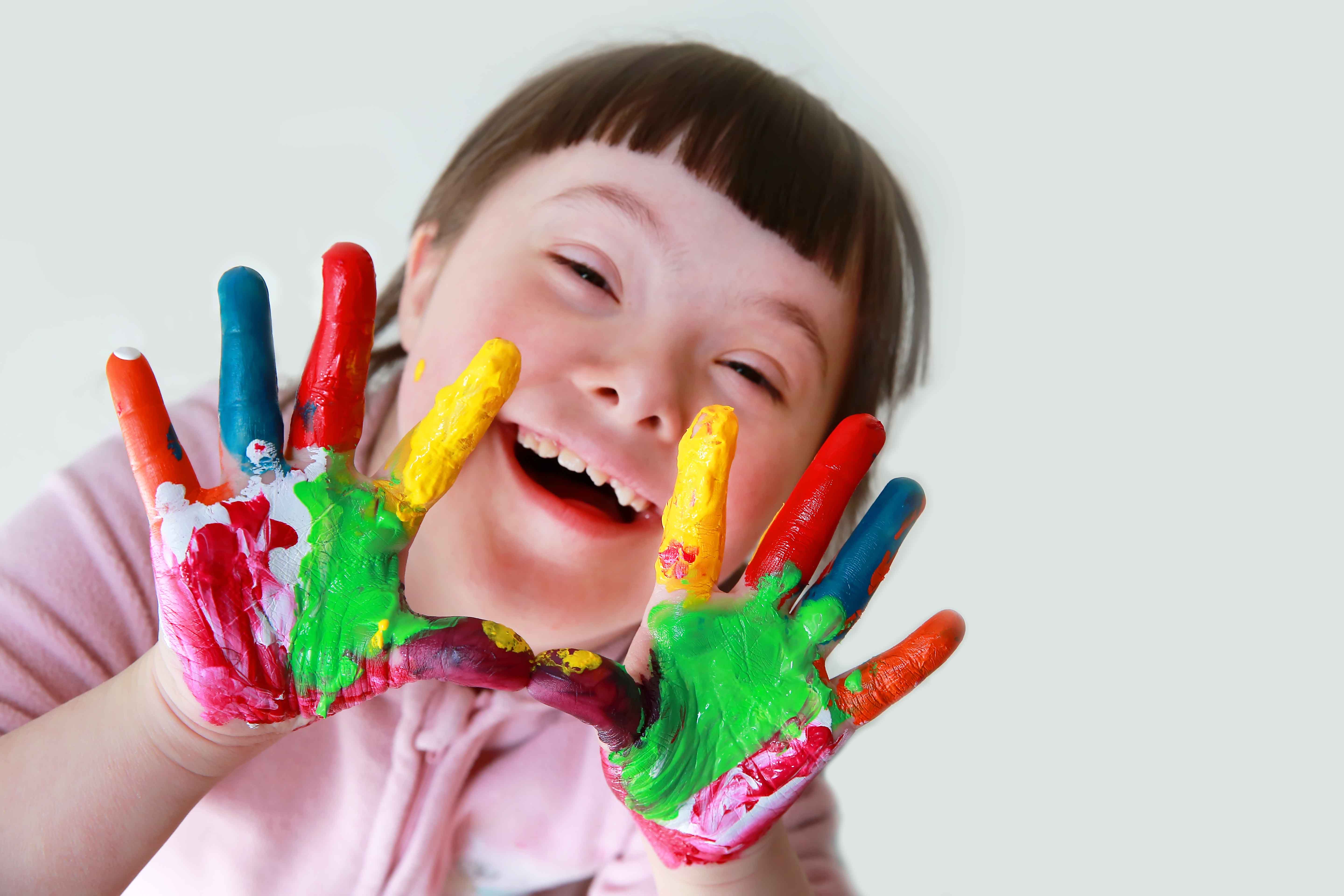 cute downs syndrome girl with painted hands
